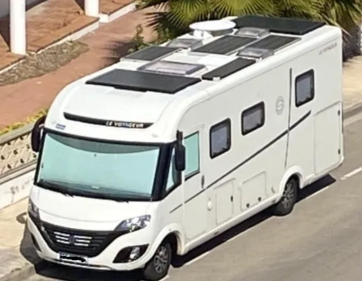 Camping-car vu de face avec vision sur des panneaux solaires, paraboles et autres installations
